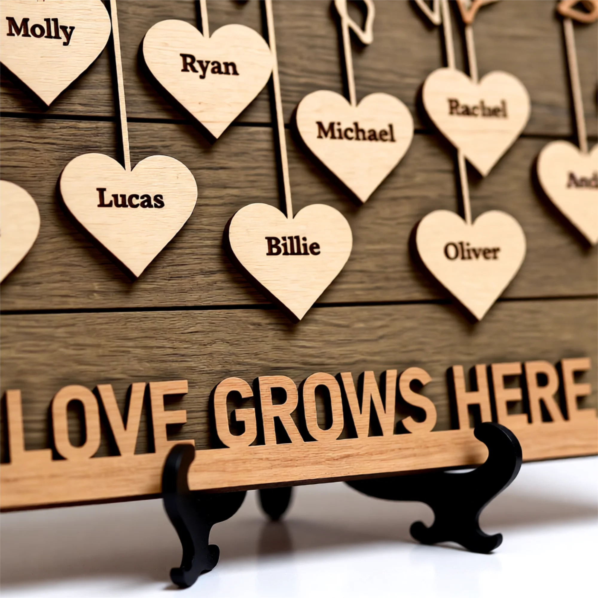 Wooden hearts with engraved names hanging from a family tree branch with 'Love Grows Here' along the bottom of the sign.