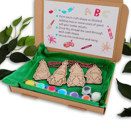 Wooden gnome shapes with paint supplies in a box